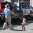 Parent and child walking to car from San  Mateo Gymnastics on Karen Road, Belmont, CA